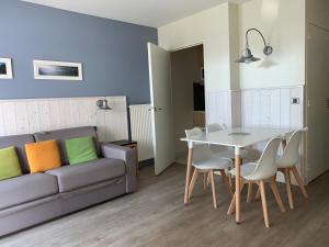 un soggiorno con un divano e un tavolo di Appartement dans résidence de standing avec terrasse et vue mer a Le Pouliguen