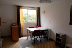 a room with a table and chairs and a window at Studio 16 Le Cap d'Agde avec Parking privé proche du centre in Cap d'Agde +15 photos