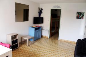 a living room with a blue dresser and a mirror at Studio 16 Le Cap d'Agde avec Parking privé proche du centre in Cap d'Agde