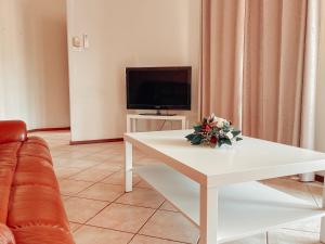 sala de estar con mesa blanca y TV en Carnarvon 3BR & 2BA Holiday House en Carnarvon