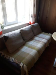 eine Couch vor einem Fenster in der Unterkunft Patarei Apartment in Tallinn