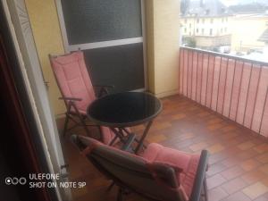 a balcony with a table and two chairs and a screen at Ferienwohnung Claudia & Dino in Lahnstein