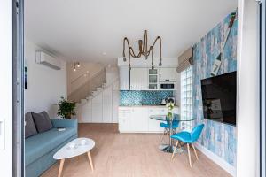 a living room with a blue couch and a table at Lapwing Residence Sopot in Sopot