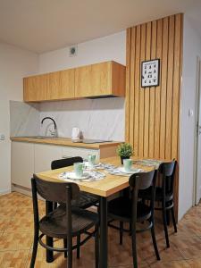 a kitchen with a table and chairs in a kitchen at 4 Pory Roku Apartamenty Domki Pokoje in Nadole