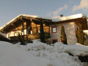 a house with snow in front of it at Appartements Renate in Kirchberg in Tirol