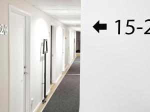 un couloir avec une porte et un panneau indiquant des centimètres dans l'établissement Mosebacke Hostel, à Stockholm