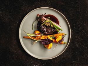 a plate of food with vegetables on a table at Mercure Han-sur-Lesse in Han-sur-Lesse