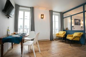 uma sala de estar com uma mesa de jantar e cadeiras em Péribleu em Périgueux