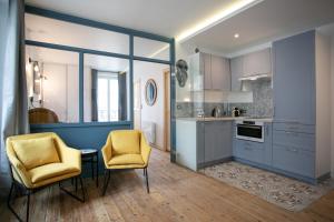 una cocina con armarios azules y 2 sillas amarillas en Péribleu, en Périgueux