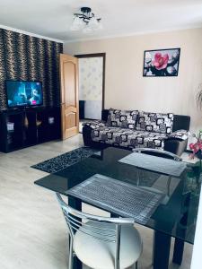 a living room with a glass table and a couch at City Centre Apartment on Krylenko 7 in Mogilev