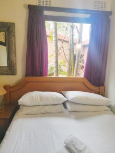 San Lameer Villa, Beach Estate, South Coast KZN في Marina Beach: غرفة نوم بسرير كبير مع نافذة