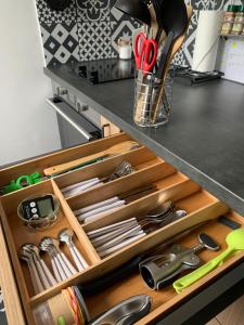 a kitchen drawer filled with lots of kitchen utensils at Résidence ESMERALDA meublé de tourisme 3 étoiles in Rochefort