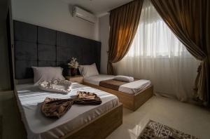 two beds in a room with a window at Gardenia Inn in Cairo