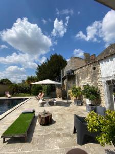 a patio with a table and chairs and a pool at Domaine de Rennebourg in Saint Denis Du Pin