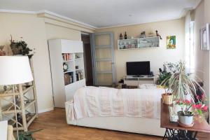 a living room with a white couch and a television at Apartamento moderno muy acogedor y luminoso •León in León
