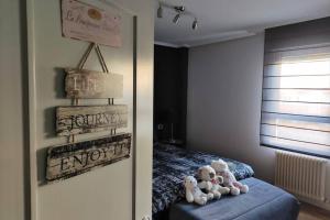 dos ositos de peluche sentados en un taburete azul en un dormitorio en Apartamento moderno muy acogedor y luminoso •León en León