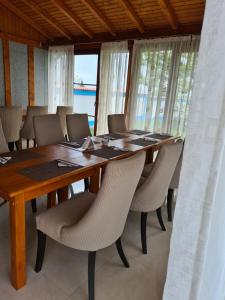 Casa Matei في مهموديا: غرفة طعام مع طاولة وكراسي خشبية