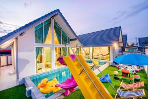 a house with a swimming pool with a slide at M4 Billion Pool Villa Cha-am in Cha Am