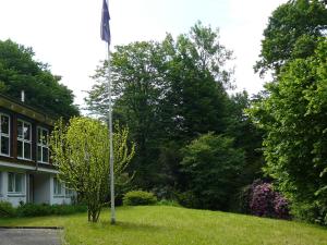 un poste de bandera en el césped frente a una casa en Ferienwohnung am Krippenhof, en Baden-Baden