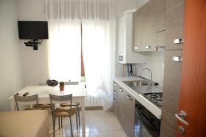 a kitchen with a sink and a table with chairs at B&B Europa in Potenza