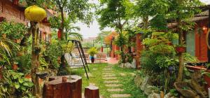 un jardín con una pasarela con árboles y plantas en Vu's Homestay, en Phong Nha