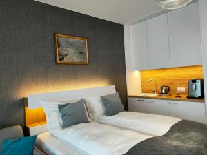 コウォブジェクにあるApartament 309 Natalie Seaside Parkのベッドルーム1室(白いシーツと青い枕のベッド1台付) +25枚の写真