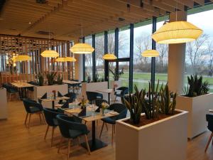 コウォブジェクにあるApartament 309 Natalie Seaside Parkのテーブルと椅子とシャンデリアのあるレストラン