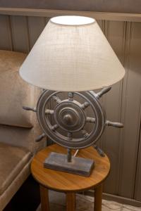 a lamp on a table with a lamp shade on it at Huoneistohotelli Tarjanne Virrat in Virrat +59 photos