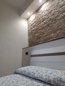 um quarto com uma cama e uma parede de tijolos em Soggiorno in Relax em Correggioverde