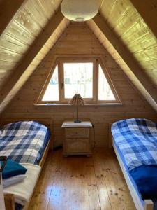 two beds in a small room in a log cabin at Domek w Brzozach in Sasino