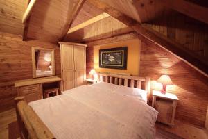 a bedroom with a bed in a wooden attic at Art Apartments Minic in Kolašin