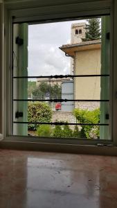 een open raam met uitzicht op een gebouw bij B&B Taverna Paradiso in SantʼAmbrogio di Valpolicella