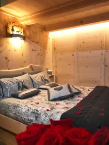 ボルミオにあるAl Bait Del Legn 1のベッドルーム1室(花の飾られたベッド1台付)