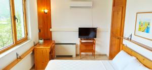 Uma TV ou centro de entretenimento em Swiss Eviniz Hotel