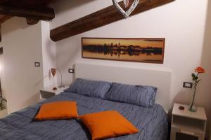 a bedroom with a blue bed with an orange pillow at Fiordiloto57 in Mantova