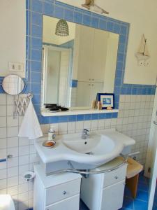 ein Badezimmer mit einem weißen Waschbecken und einem Spiegel in der Unterkunft M292 - Marcelli, quadrilocale con giardino a 50mt dal mare in Marcelli