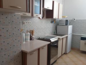 a kitchen with a white counter and a refrigerator at Simon Apartman in Tiszafüred