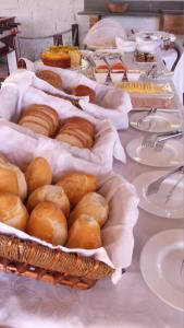 een tafel met manden brood en gebak bij Chalés Do Sol in Boracéia