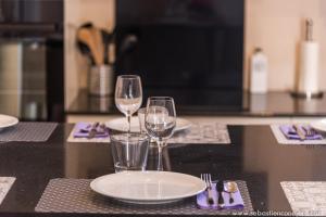 a table with two wine glasses and plates on it at La case Maui in La Saline les Bains