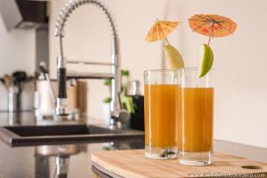 dos vasos de jugo de naranja sentados en una tabla de cortar en La case Maui, en La Saline-Les-Bains