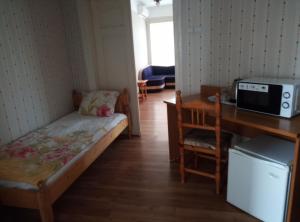 a small room with a bed and a desk with a microwave at Casablanca City in Varna City