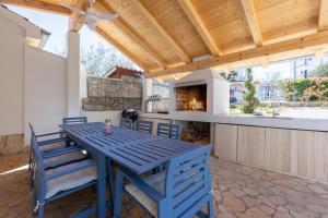 a blue table and chairs on a patio with a fireplace at Villa Liva in Vantačići