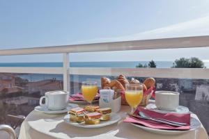 un tavolo con prodotti per la colazione e 2 bicchieri di succo d'arancia di Hotel Sant Jordi a Tarragona