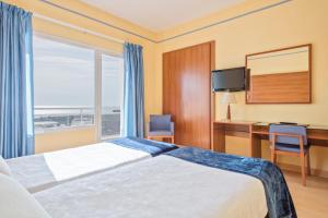 a hotel room with a bed and a desk and a window at Hotel Sant Jordi in Tarragona