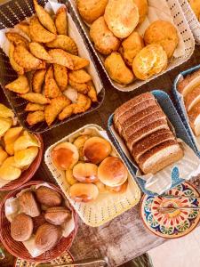 a table topped with different types of bread and pastries at Pousada Quintal da Lua in Capitólio