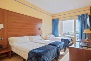 a hotel room with two beds and a window at Hotel Sant Jordi in Tarragona