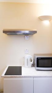 a kitchen counter with a microwave and a toaster oven at Abingdon Lodge & Suit in Ryde