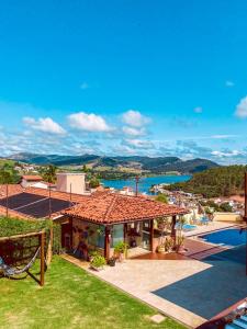 a villa with a swimming pool and a resort at Pousada Quintal da Lua in Capitólio