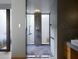 a bathroom with a shower, sink, and mirror at Agora Tokyo Ginza in Tokyo