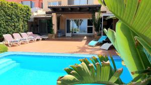 una piscina con sillas y un montón de plantas en Exclusive Villa Golf Private Pool, en Adeje